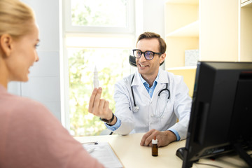 Cheerful doctor giving drugs to female stock photo