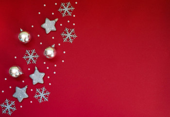 Fototapeta na wymiar Christmas still life. Silver and gold decorative Christmas ornaments on a red background. Christmas, winter, new year concept. Flat lay, top view, copy space.