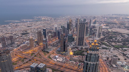 Fototapeta na wymiar Downtown of Dubai night timelapse before sunrise. Aerial view with towers and skyscrapers