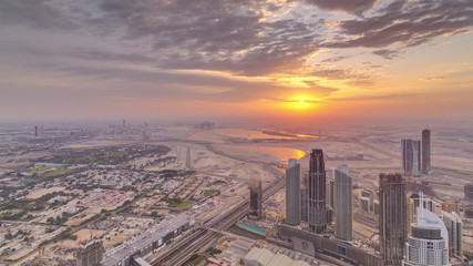 Naklejka na ściany i meble Downtown of Dubai in the morning timelapse during sunrise. Aerial view with towers and skyscrapers