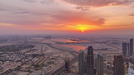 Naklejka na ściany i meble Downtown of Dubai in the morning timelapse during sunrise. Aerial view with towers and skyscrapers