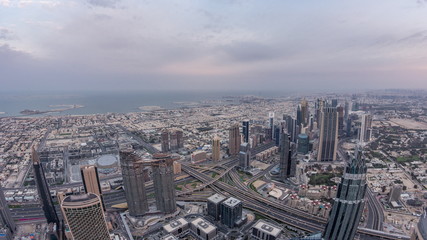 Naklejka na ściany i meble Downtown of Dubai night to day timelapse before sunrise. Aerial view with towers and skyscrapers