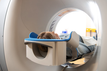 Female patient lying on table inside CT machine