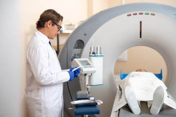 Doctor preparing catheter during CT scan procedure