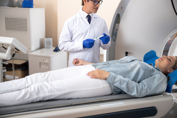 Doctor holding venflon catheter and looking at patient