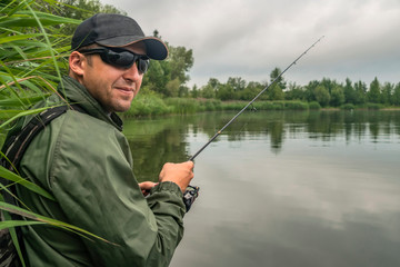 Fishing. Fisherman in action, man catch fish by spinning rod