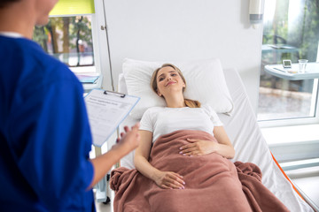 Obraz premium Beautiful lady talking with doctor in hospital room