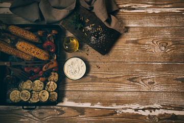 Fototapeta na wymiar Top view of rustic kitchen table with grilled vegetables on wooden vintage table. Organic vegetables ready to eating.