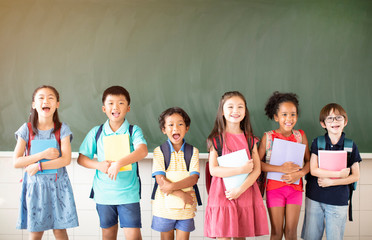 Group of diverse young students standing together in classroom