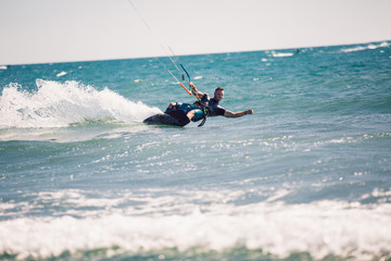 Kitesurfing. Man rides on kite on waves