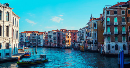 View of the canal with boats and gondolas in Venice, Italy. Venice is a popular tourist destination of Europe.