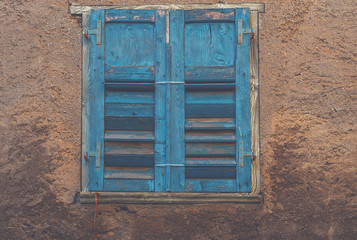 View of a old house exterior and old vintage window with wooden shutters. Seen on a Venice street.