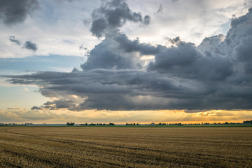 Dramatic storm clouds are forming over the wide open dutch landscape