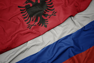 waving colorful flag of russia and national flag of albania.