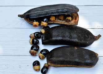 Black rosewood seeds are black and yellow, beautifully decorated on a gray wood pattern table.
