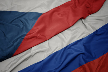waving colorful flag of russia and national flag of czech republic.