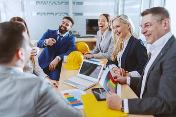 Obraz premium Group of cheerful dedicated Caucasian architects working on project together. Boardroom interior.