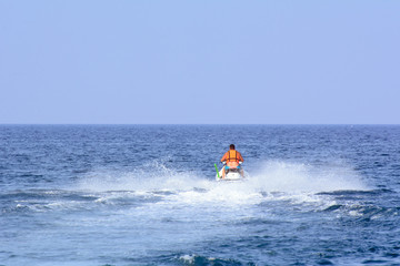 Fototapeta na wymiar a man on a jet ski floats on the sea. Concept - outdoor activities