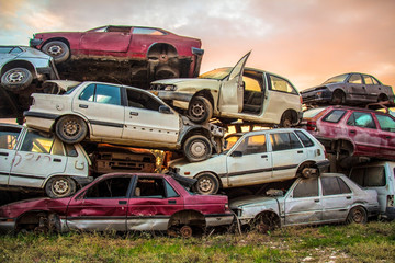 dump of old cars on green grass at sunny day 