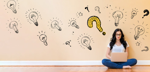 Question with light bulbs with young woman using a laptop computer
