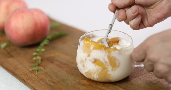 Eating dessert with peach, plum compote and ice cream