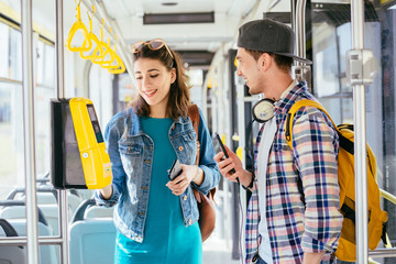 stylish male traveler with map in hand asking for help woman with headphones and backpack at subway