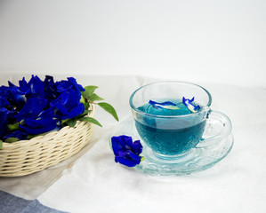 cup of pea tea and flowers on table