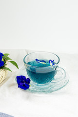 Obraz na płótnie Canvas cup of pea tea and flowers on table