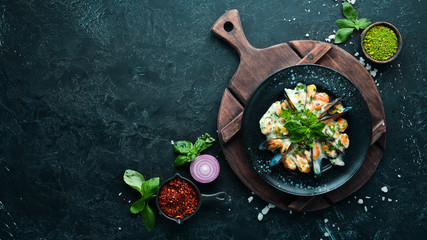 Mussels in cream sauce with basil. In the old background. Top view. Free copy space.