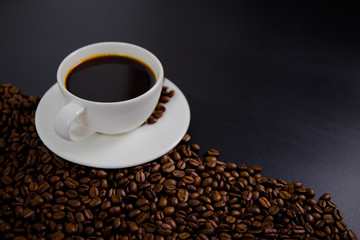 cup of coffee with beans on black background