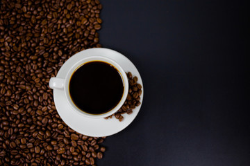 cup of coffee with beans on black background
