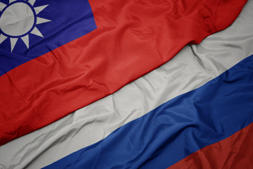 waving colorful flag of russia and national flag of taiwan.