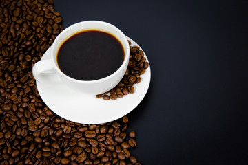 cup of coffee with beans on black background