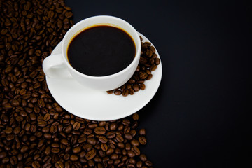 cup of coffee with beans on black background