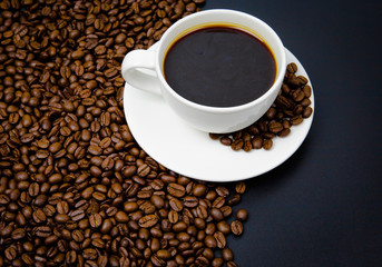 cup of coffee with beans on black background