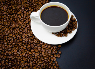 cup of coffee with beans on black background