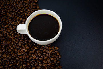cup of coffee with beans on black background