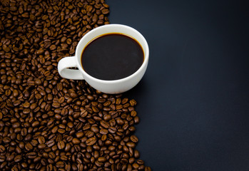 cup of coffee with beans on black background