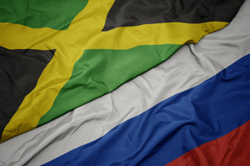 waving colorful flag of russia and national flag of jamaica.