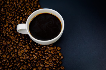 cup of coffee with beans on black background
