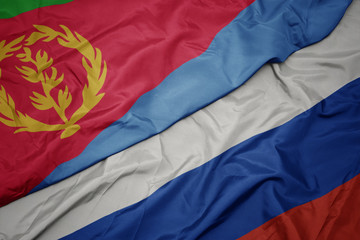waving colorful flag of russia and national flag of eritrea.