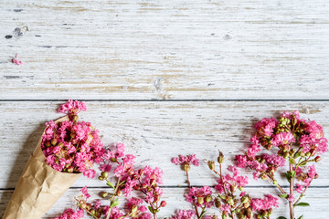 Spring Rustic background with pink flowers. Copy space on white wood. Valentine day internet sales concept, online shopping holiday background. Mockup, top view, flat lay