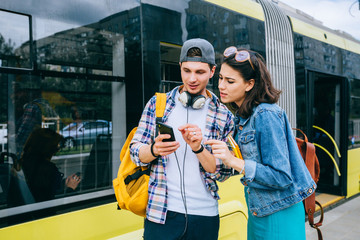 Tourist friends searching locations with a tablet sightseeing in a city street