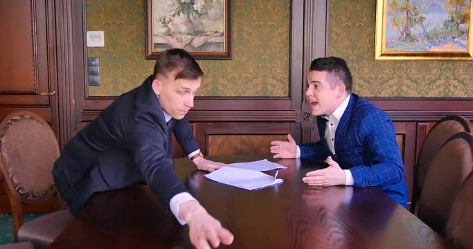 Two young businessmen are trying to come to an agreement and find a compromise, but they curse, scream, fight. Office, nerves, torn deal, inappropriate conditions, bad, aggressive