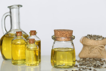Organic sunflower oil in glass bottles and sunflower seed on white background