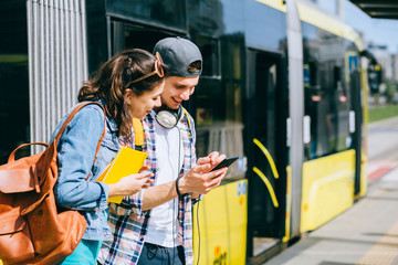 Tourist friends searching locations with a tablet sightseeing in a city street