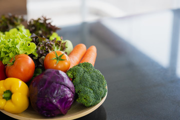 Mix fresh vegetable on wood plate with black table background