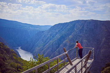 Fototapeta na wymiar Young man contemplating the Sil Canyon from Xariñas do Castro viewpoint in Galicia, Spain