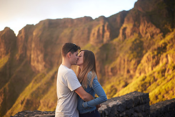 Young couple kissing in front of the Macizo de Teno in Tenerife, Canary Islands, Spain