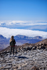 Fototapeta premium Young woman contemplating the entire Tenerife island from the top of the Teide Volcano